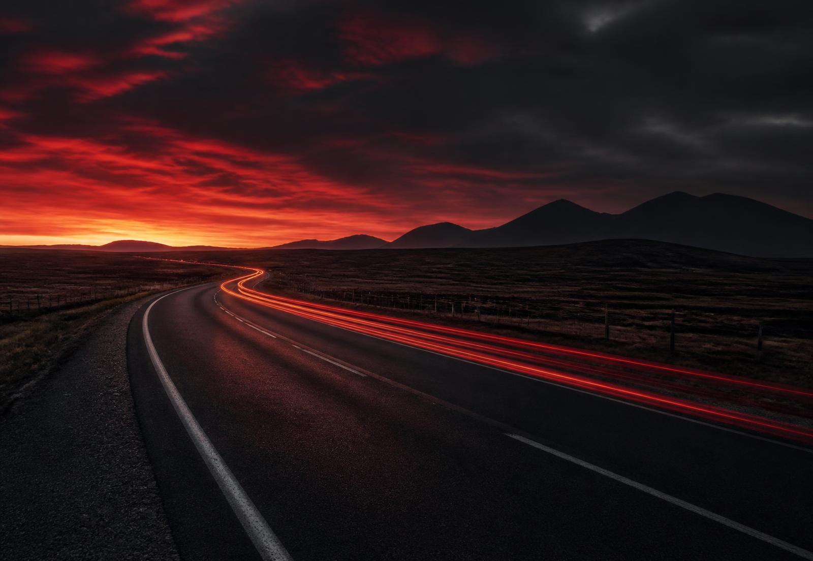 Estrada ao anoitecer com rastros de luz